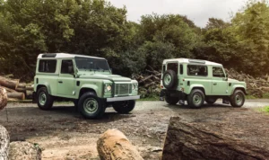 A restored Defender cruising down a rugged country road, ready for its new adventures.